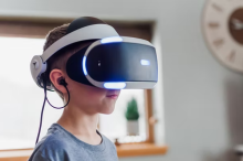 child with a virtual reality headset over his eye on head